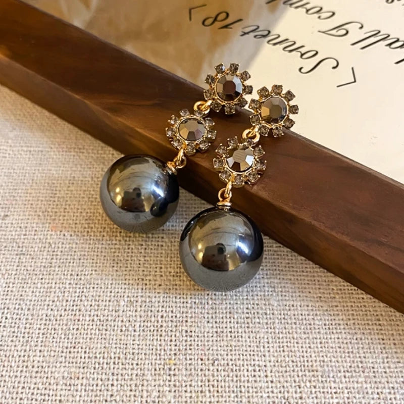 Close-up detail of the sparkling zircons and plating on the gold drop earrings