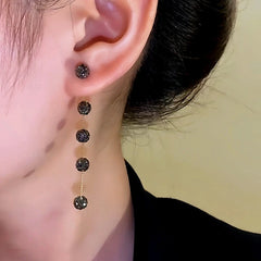 Model showcasing the dangle and style of the 14K Gold-Plated Black Diamond Long Tassel Earrings