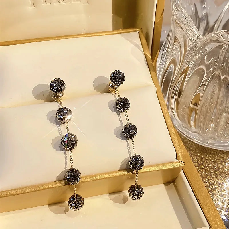 Angled view of the 14K Gold-Plated Black Diamond Long Tassel Earrings