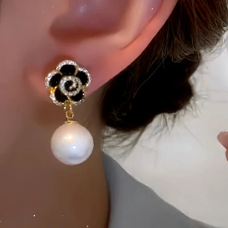 Model showcasing the dangle and style of the 14K Gold-Plated Black Rose Pearl Earrings