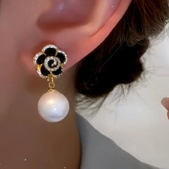 Model showcasing the dangle and style of the 14K Gold-Plated Black Rose Pearl Earrings