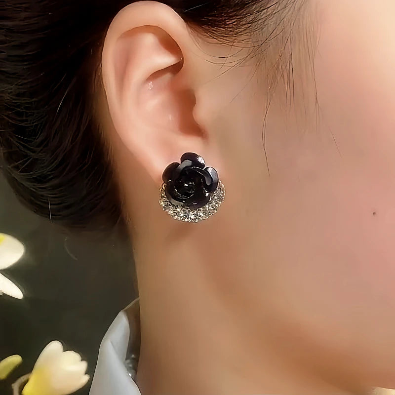 Model showcasing the dangle and style of the 14K Gold-Plated Black Rose Stud Earrings