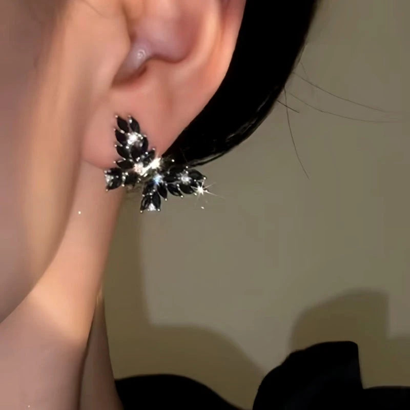 Model showcasing the dangle and style of the 14K Gold-Plated Black Zircon Butterfly Earrings