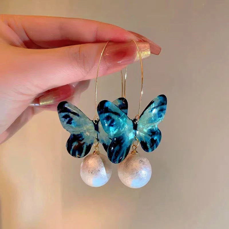 Angled view of the 14K Gold-Plated Blue Butterfly Pearl Pendant Ear Hook Earrings