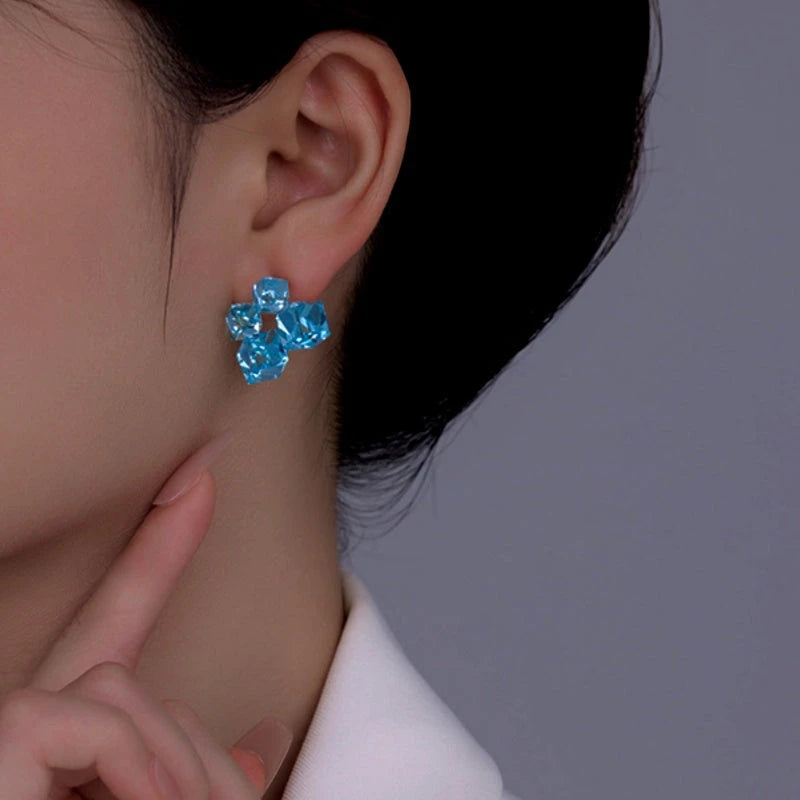 Model showcasing the dangle and style of the 14K Gold-Plated Blue Crystal Stud Earrings