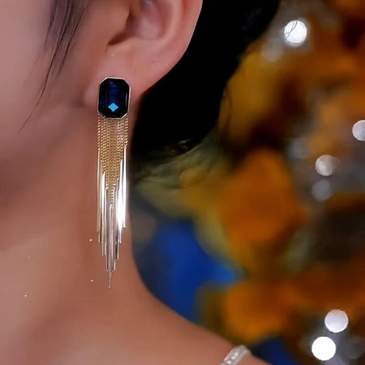 Model showcasing the dangle and style of the 14K Gold-Plated Blue Crystal Tassel Earrings