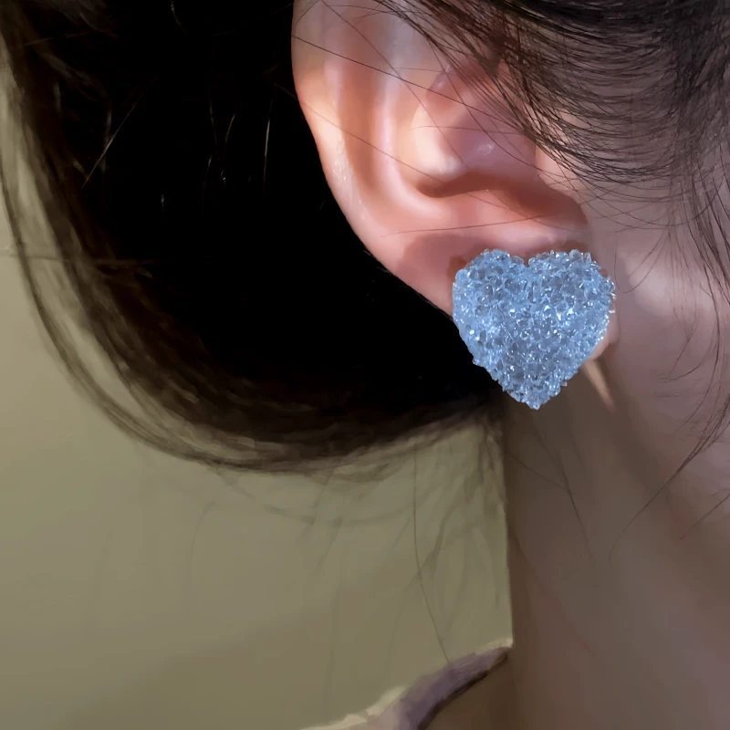 Model showcasing the dangle and style of the 14K Gold-Plated Blue Zircon Crystal Heart Stud Earrings