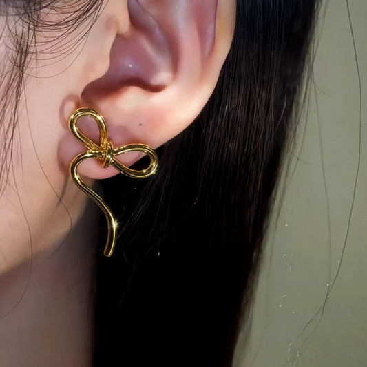 Model showcasing the dangle and style of the 14K Gold-Plated Bow Pearl Earrings