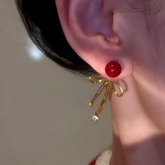Close-up detail of the sparkling zircons and plating on the Red Bow Earrings