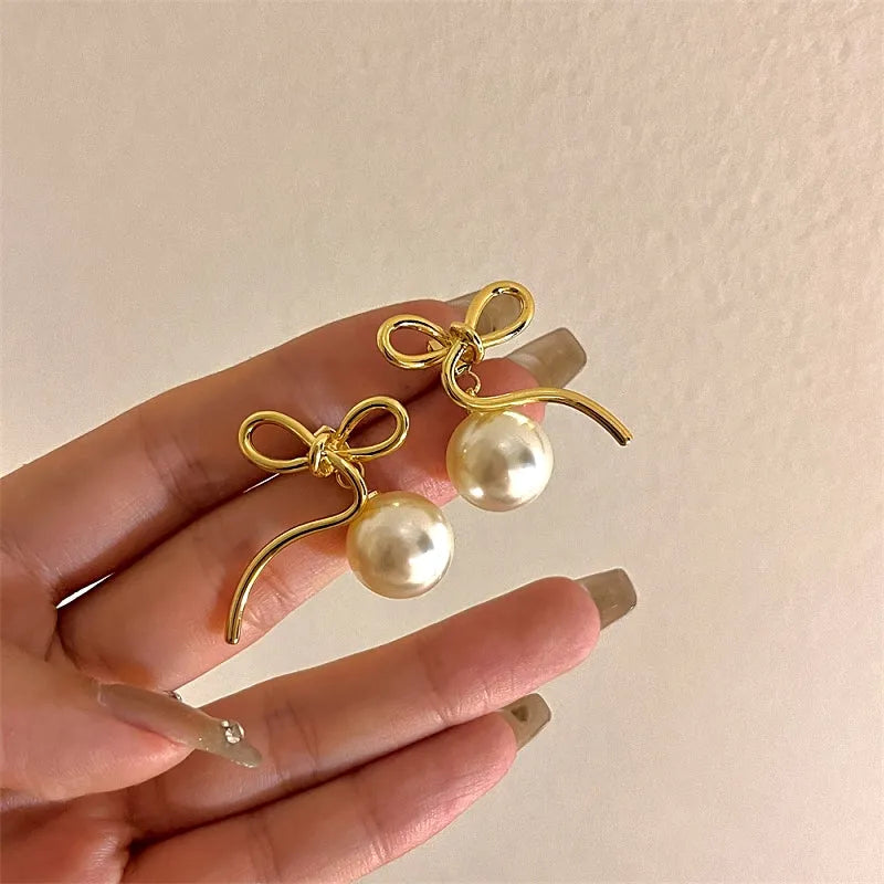 Angled view of the 14K Gold-Plated Bow Pearl Earrings