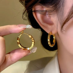 Model showcasing the dangle and style of the 14K Gold-Plated Broken Diamond Hoop Earrings