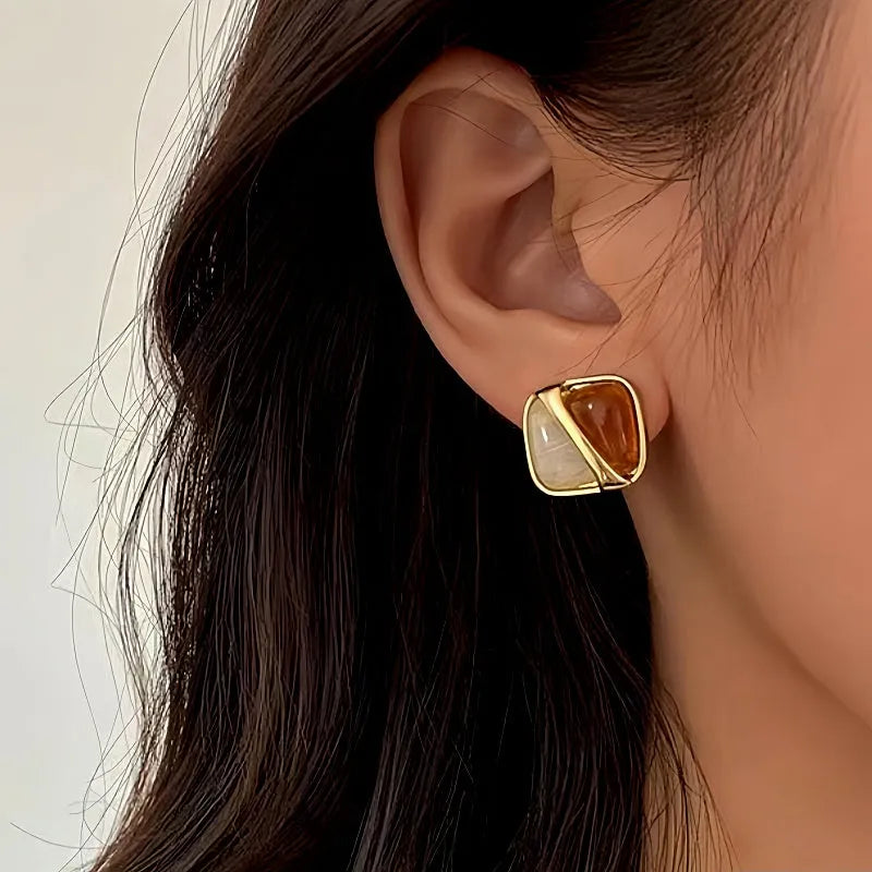 Model showcasing the dangle and style of the 14K Gold-Plated Brown And White Square Earrings