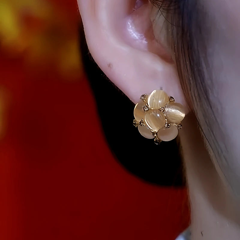 Model showcasing the dangle and style of the 14K Gold-Plated Brown Cat's Eye Flower Earrings