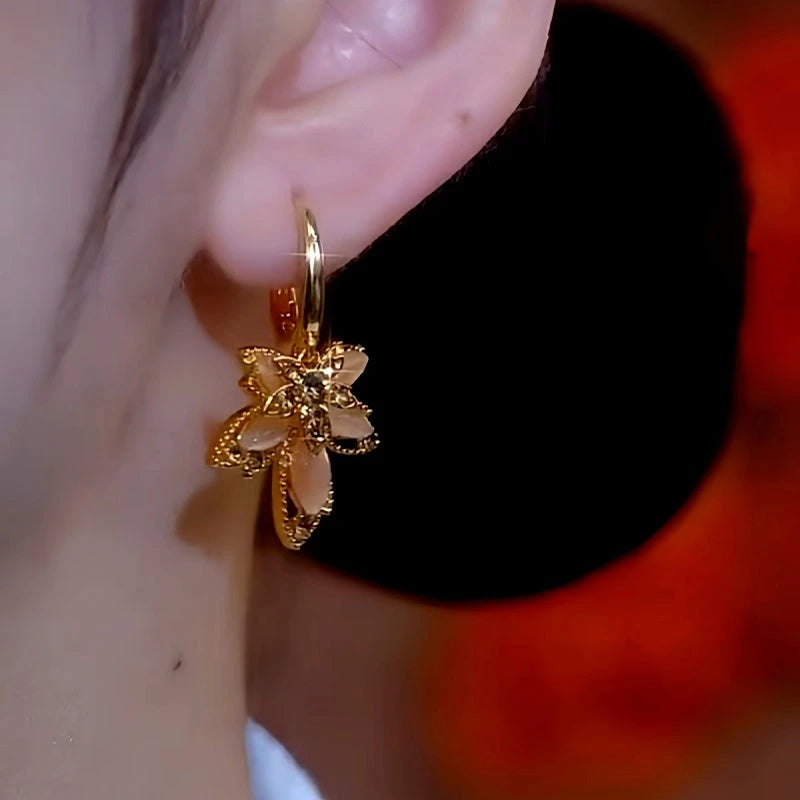 Model showcasing the dangle and style of the 14K Gold-Plated Brown Crystal Flower Earrings