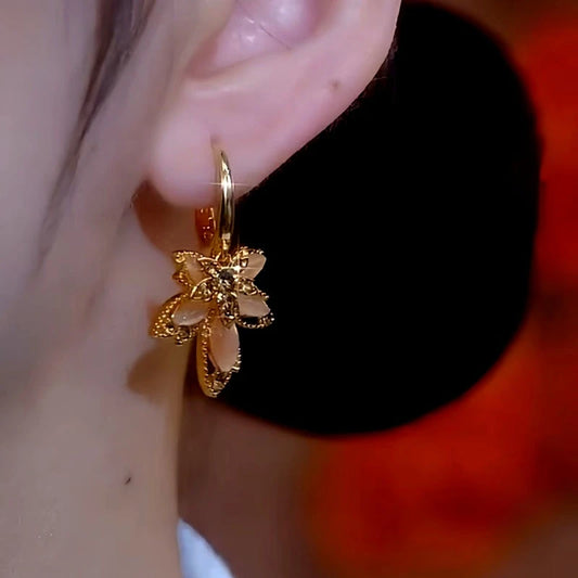 Model showcasing the dangle and style of the 14K Gold-Plated Brown Crystal Flower Earrings