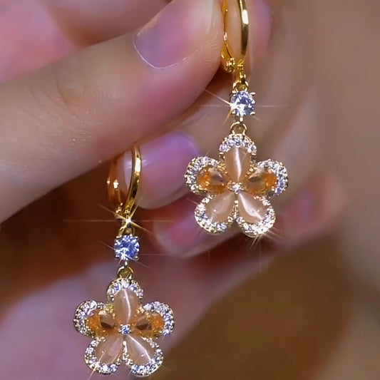Model showcasing the dangle and style of the 14K Gold-Plated Brown Crystal Flower Earrings