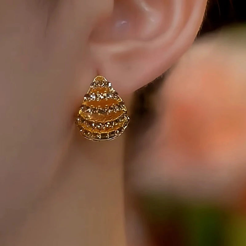 Model showcasing the dangle and style of the 14K Gold-Plated Brown Diamond Double-Sided Basket Ear Buckle Earrings
