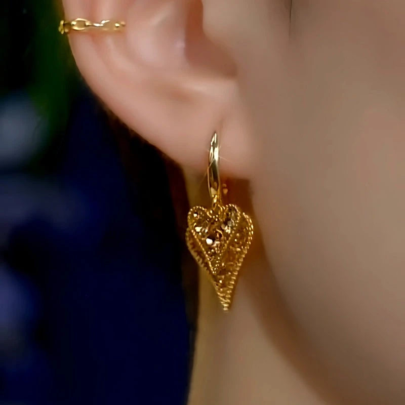 Model showcasing the dangle and style of the 14K Gold-Plated Brown Diamond Double Heart Earrings