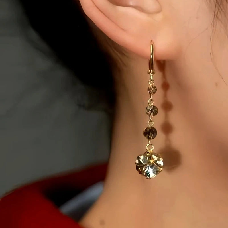 Model showcasing the dangle and style of the 14K Gold-Plated Brown Diamond Earrings