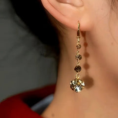 Model showcasing the dangle and style of the 14K Gold-Plated Brown Diamond Earrings