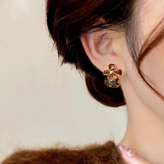 Model showcasing the dangle and style of the 14K Gold-Plated Brown Diamond Flower Earrings