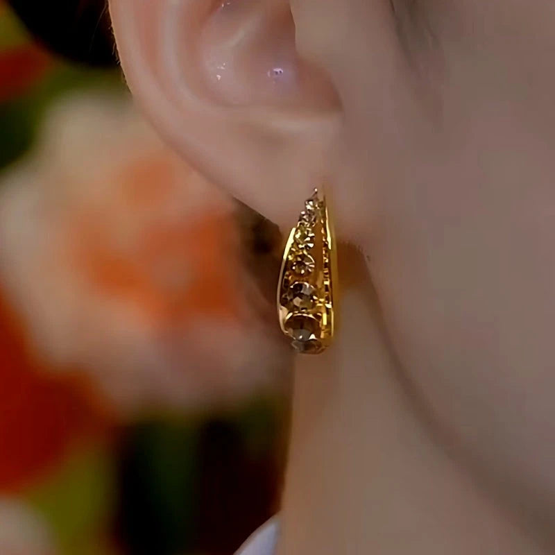 Model showcasing the dangle and style of the 14K Gold-Plated Brown Diamond Hoop Earrings