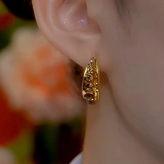 Model showcasing the dangle and style of the 14K Gold-Plated Brown Diamond Hoop Earrings