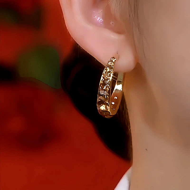 Model showcasing the dangle and style of the 14K Gold-Plated Brown Diamond Hoop Earrings