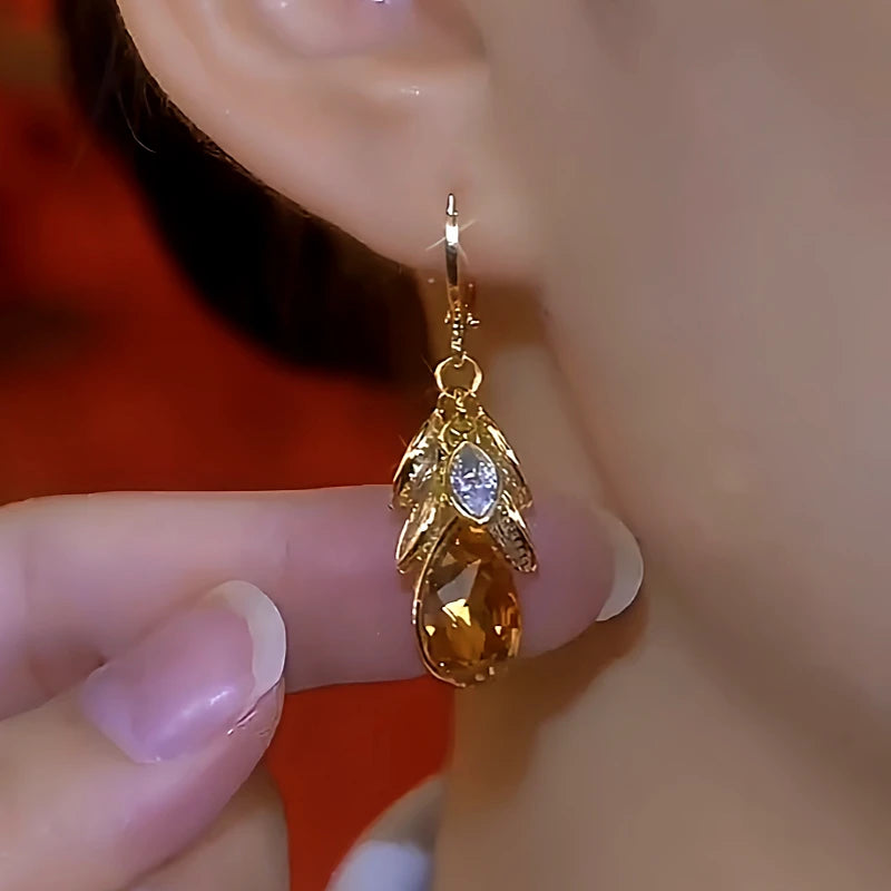 Model showcasing the dangle and style of the 14K Gold-Plated Brown Diamond Leaf Drop Earrings