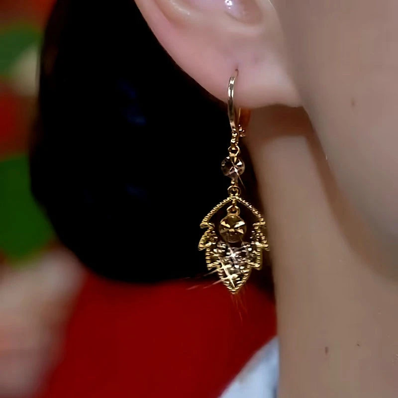 Model showcasing the dangle and style of the 14K Gold-Plated Brown Diamond Leaf Earrings
