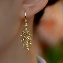 Close-up detail of the sparkling zircons and plating on the gold leaf earrings