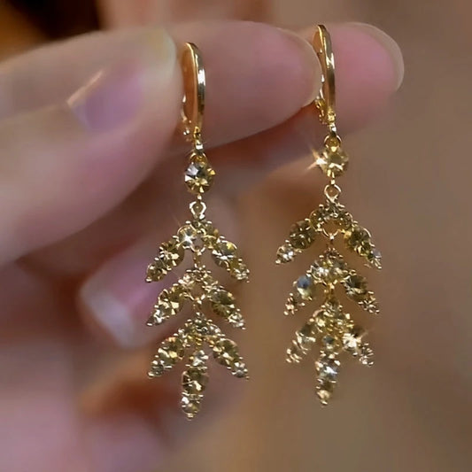Model showcasing the dangle and style of the 14K Gold Plated Brown Diamond Leaf Earrings