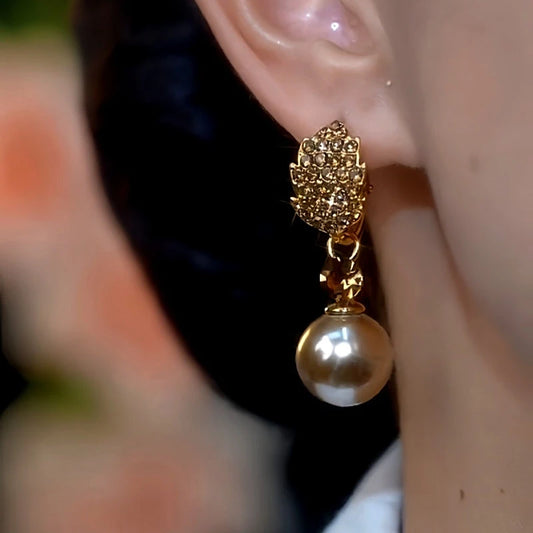 Model showcasing the dangle and style of the 14K Gold-Plated Brown Diamond Pearl Leaf Earrings