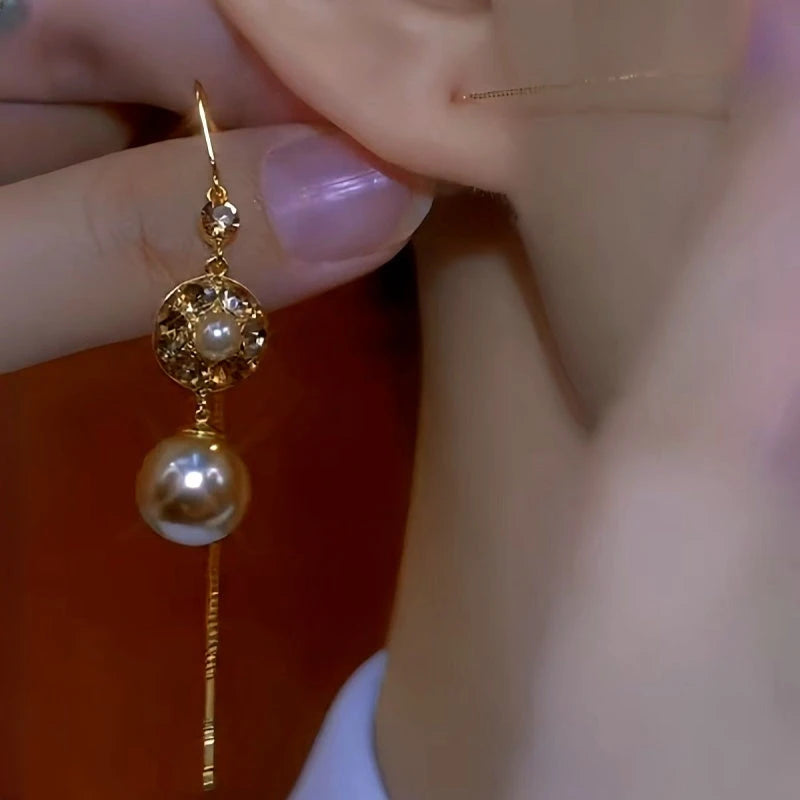 Model showcasing the dangle and style of the 14K Gold-Plated Brown Diamond Pearl Tassel Threader Earrings