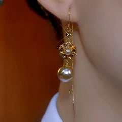Angled view of the 14K Gold-Plated Brown Diamond Pearl Tassel Threader Earrings