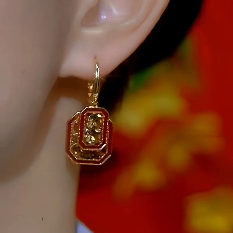 Model showcasing the dangle and style of the 14K Gold-Plated Brown Diamond Red Retro Square Earrings