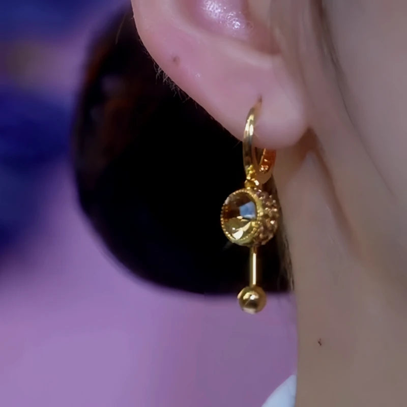 Model showcasing the dangle and style of the 14K Gold-Plated Brown Diamond Tassel Earrings