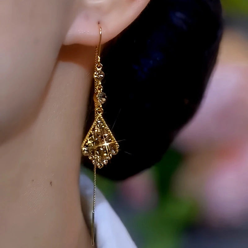 Model showcasing the dangle and style of the 14K Gold-Plated Brown Diamond Threader Tassel Earrings
