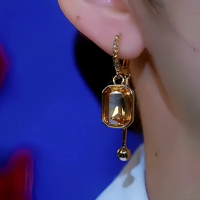 Model showcasing the dangle and style of the 14K Gold-Plated Brown Sugar Cube Crystal Earrings