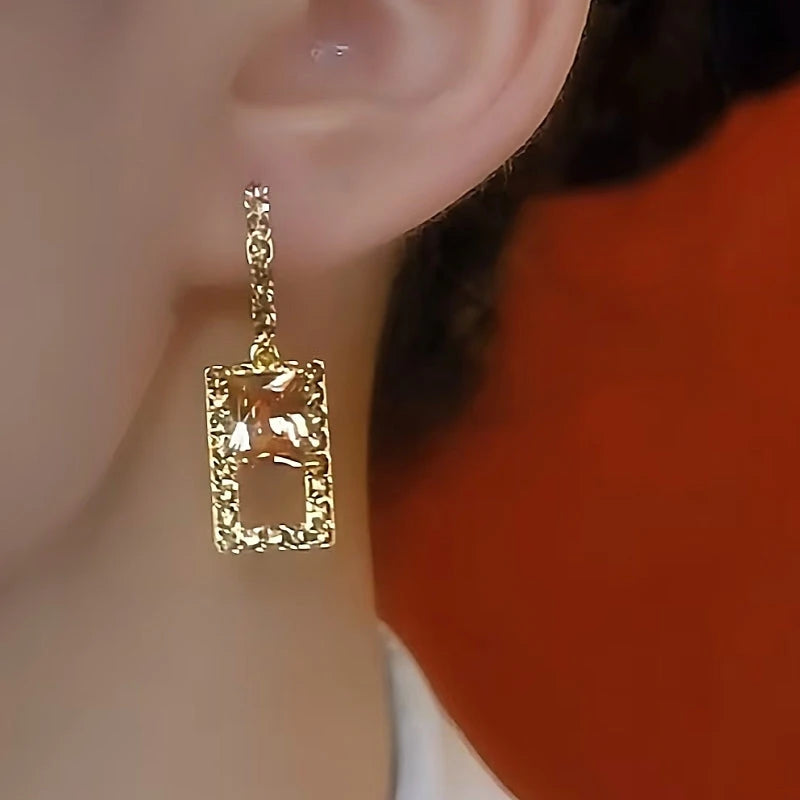 Model showcasing the dangle and style of the 14K Gold-Plated Brown Zircon Crystal Earrings