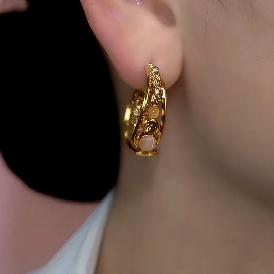 Model showcasing the dangle and style of the 14K Gold-Plated Brown Zircon Diamond Cat's Eye Stone Earrings