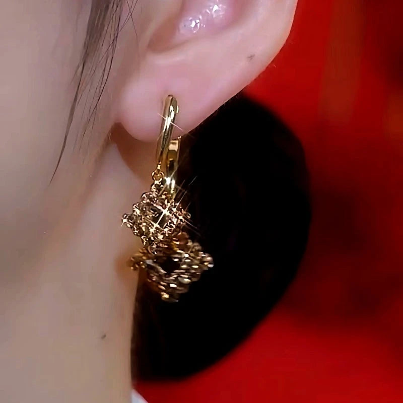 Model showcasing the dangle and style of the 14K Gold-Plated Brown Zircon Diamond Earrings