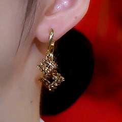 Model showcasing the dangle and style of the 14K Gold-Plated Brown Zircon Diamond Earrings