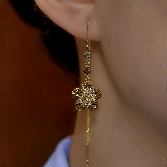 Model showcasing the dangle and style of the 14K Gold-Plated Brown Zircon Flower Threader Earrings