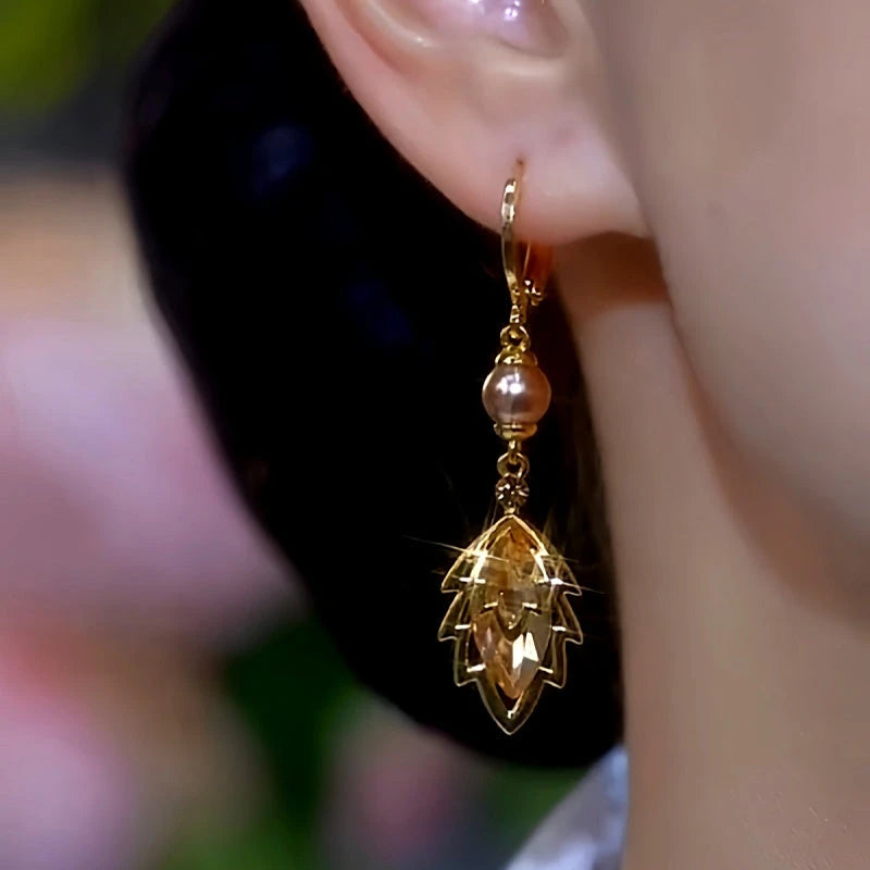 Model showcasing the dangle and style of the 14K Gold-Plated Brown Zircon Jade Leaf Pearl Earrings