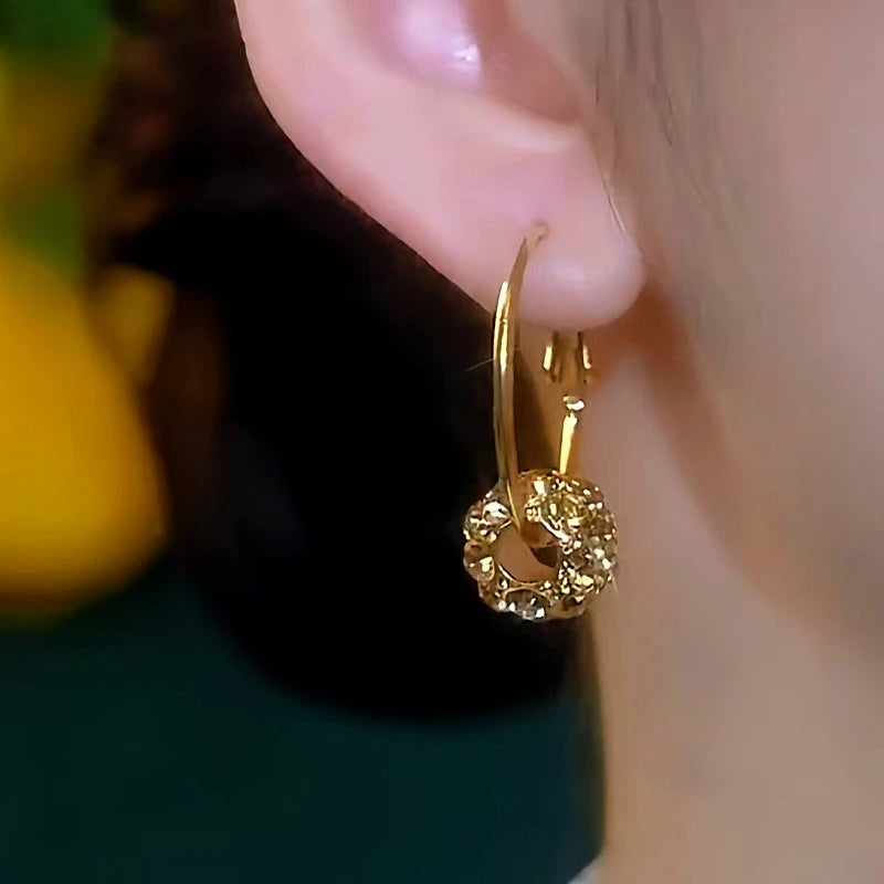 Model showcasing the dangle and style of the 14K Gold-Plated Brown Zircon Ring Hoop Earrings