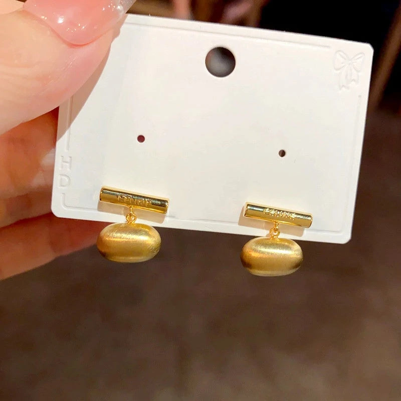 Angled view of the 14K Gold-Plated Brushed Bean Earrings