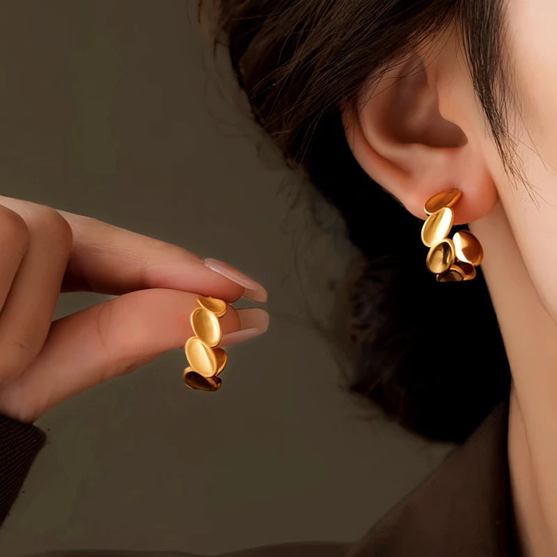 Model showcasing the dangle and style of the 14K Gold-Plated Brushed C-Shaped Earrings