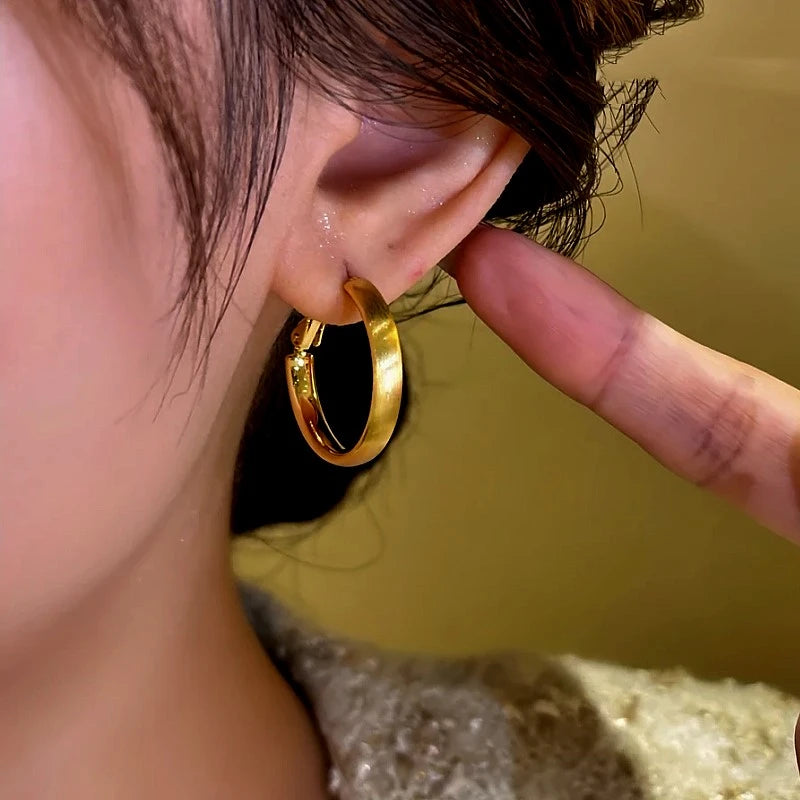 Model showcasing the dangle and style of the 14K Gold-Plated Brushed Hoop Earrings