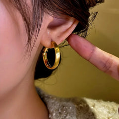 Model showcasing the dangle and style of the 14K Gold-Plated Brushed Hoop Earrings